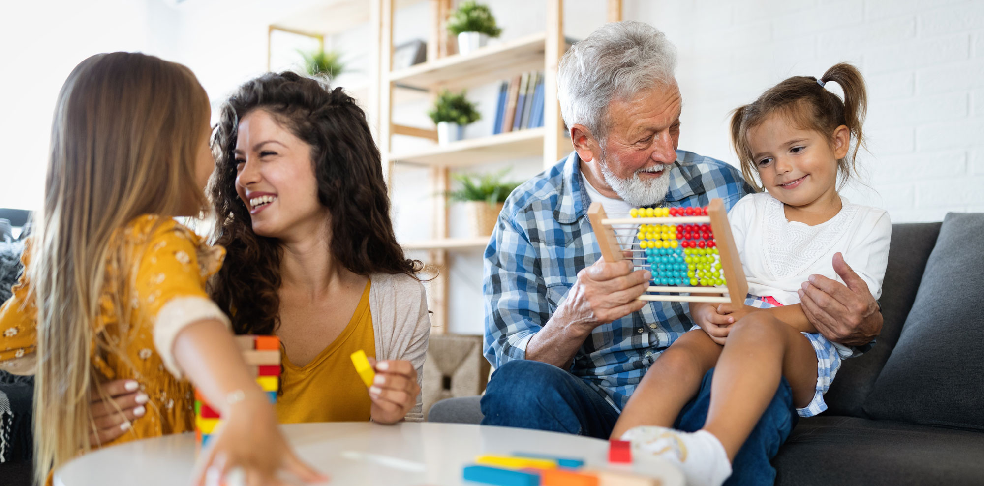 Grandpa and daughter and granddaughters interacting and learning.